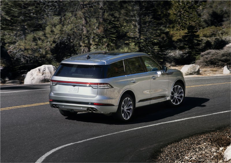 A 2023 Lincoln Aviator® Grand Touring model is shown being driven on a tight turn of a mountain road | Pinnacle Lincoln in Nicholasville KY