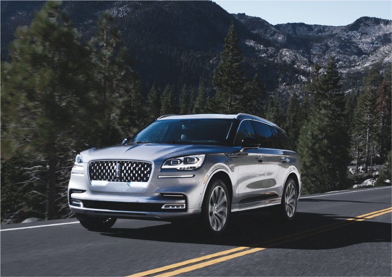 A 2023 Lincoln Aviator® Grand Touring SUV being driven on a winding road to demonstrate the capabilities of all-wheel drive | Pinnacle Lincoln in Nicholasville KY