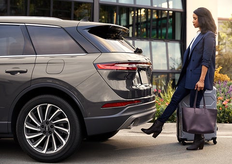 A woman with her hands full uses her foot to activate the available hands-free liftgate. | Pinnacle Lincoln in Nicholasville KY